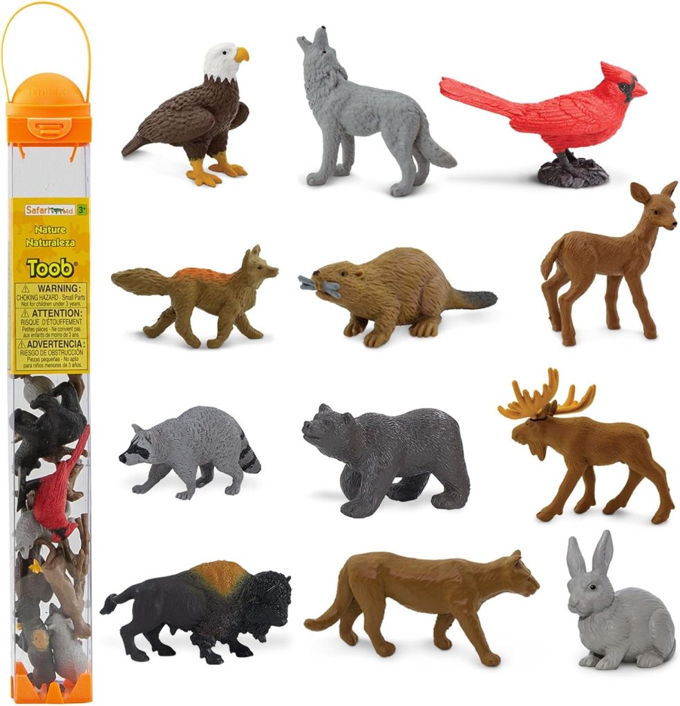A collection of toy animal figurines including an eagle, wolf, cardinal, fox, beaver, deer, raccoon, bear, moose, bison, mountain lion, and rabbit, arranged above a clear storage tube.