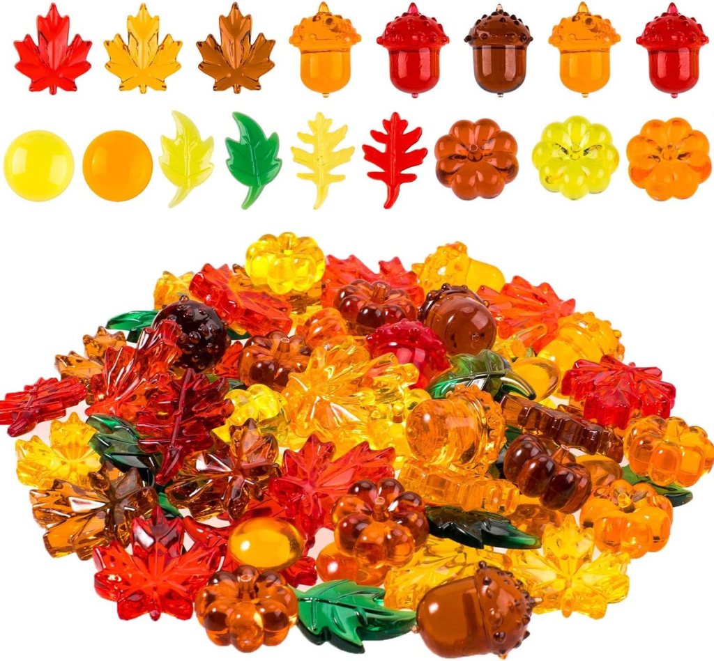 A colorful assortment of decorative plastic fall-themed pieces, including leaves, acorns, and pumpkins in various autumn colors such as red, orange, yellow, and green.