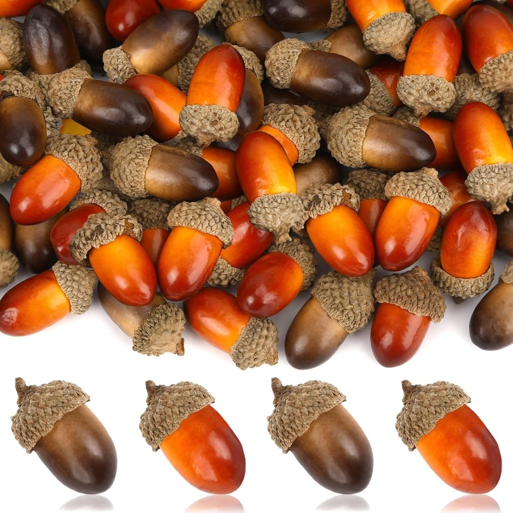 A pile of various acorns in different shades, showing some with brown, orange, and dark brown colors, all featuring rough, textured caps.